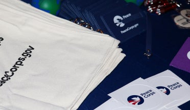 Peace Corps-branded promotional items stacked on a table
