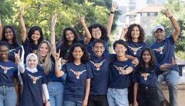 UT international students throw the Hook 'em Horns sign