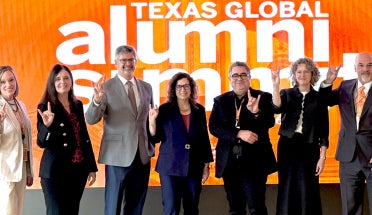 Deans and leaders from UT Austin show "Hook em" at the 2026 Alumni Summit
