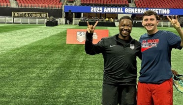 Two men hold up a "hook 'em" hand sign at the World Cup.