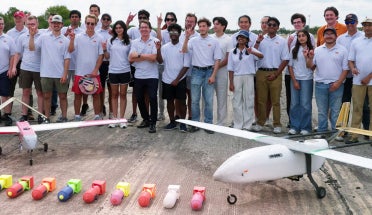 UT Austin's team for the XPRIZE Wildfire Competition stands behind the planes they built