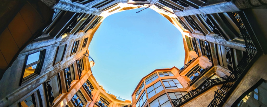 a view from the ground looking up to the sky surrounded by a circular courtyard of a building