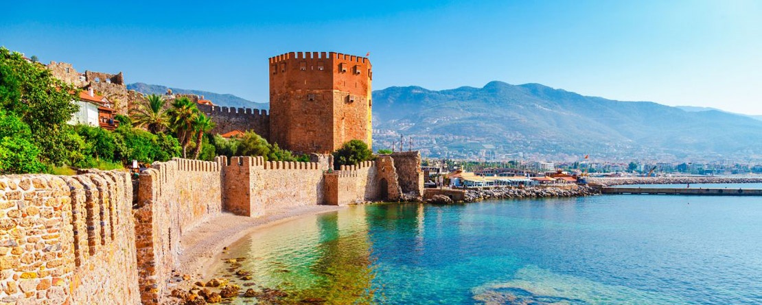 A beautiful day looking out at the ocean that borders the ancient stone walls and towers of the port city of Anatala Turkey