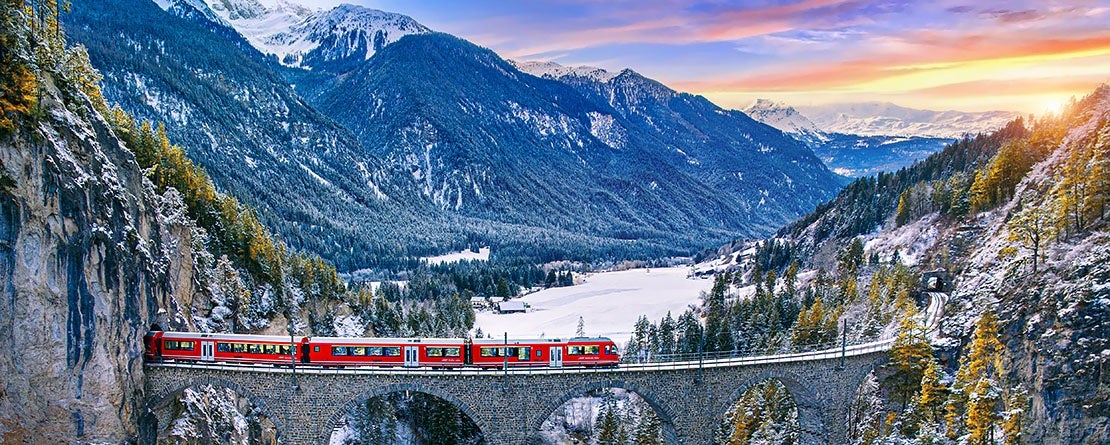 Aerial view of Train passing through the Swiss Alps in Filisur, Switzerland via the Landwasser Viaduct during winter.