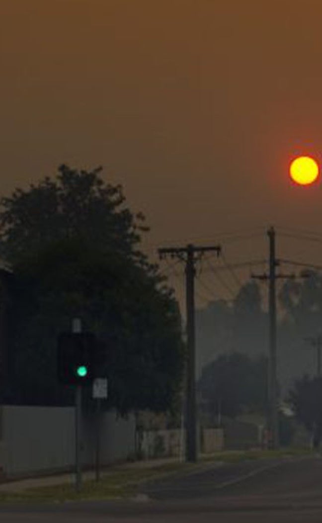 The sun sets over a hazy orange sky.
