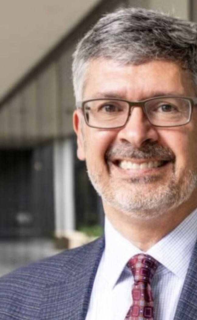 UT Austin Dean of Engineering Roger Bonnecaze smiles in a gray jacket and red tie