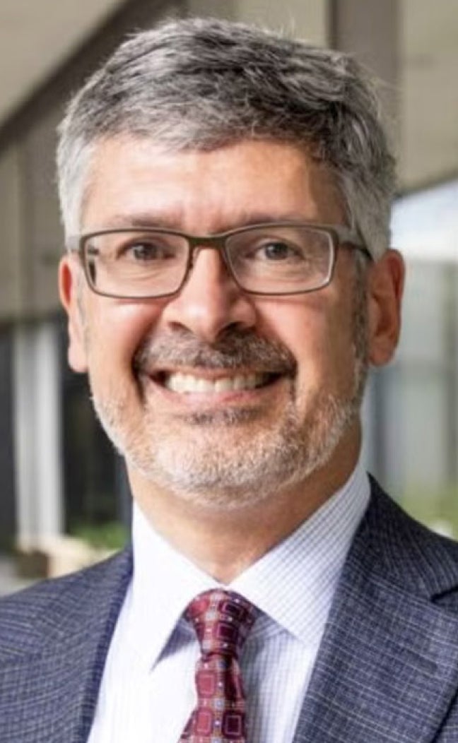 UT Austin Dean of Engineering Roger Bonnecaze smiles in a gray jacket and red tie