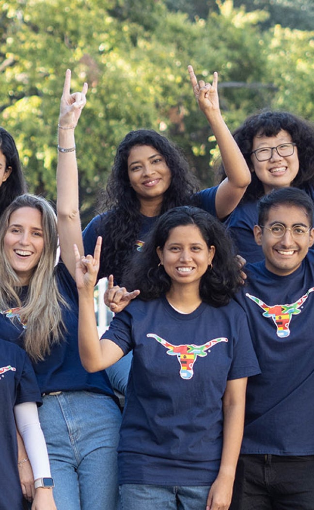 UT international students throw the Hook 'em Horns sign