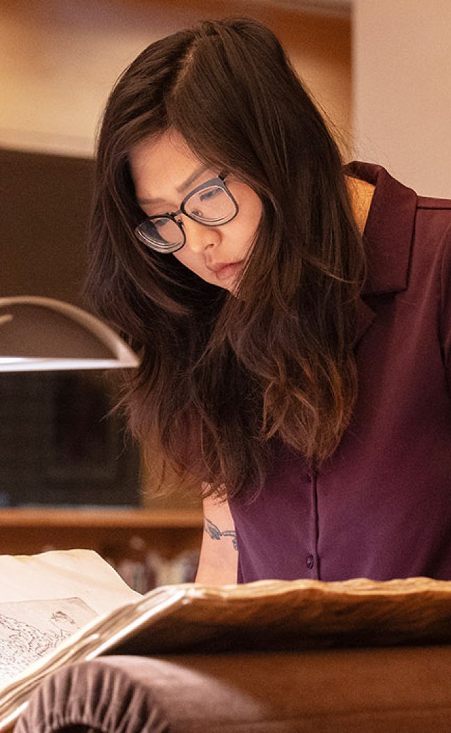 A researcher bends over a manuscript at the Harry Ransom Center