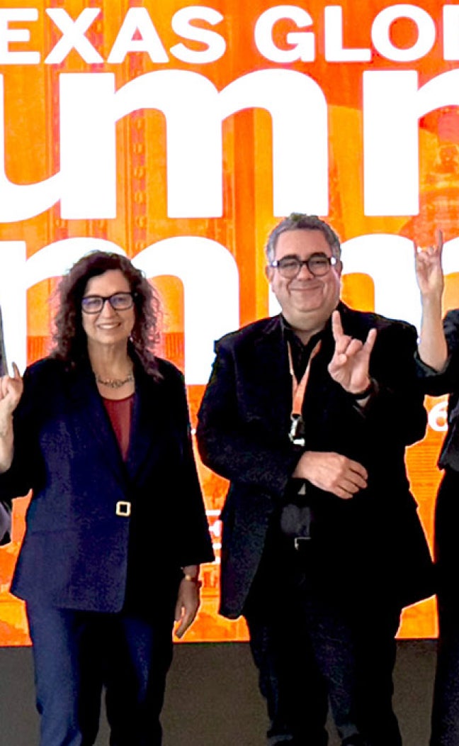 Deans and leaders from UT Austin show "Hook em" at the 2026 Alumni Summit