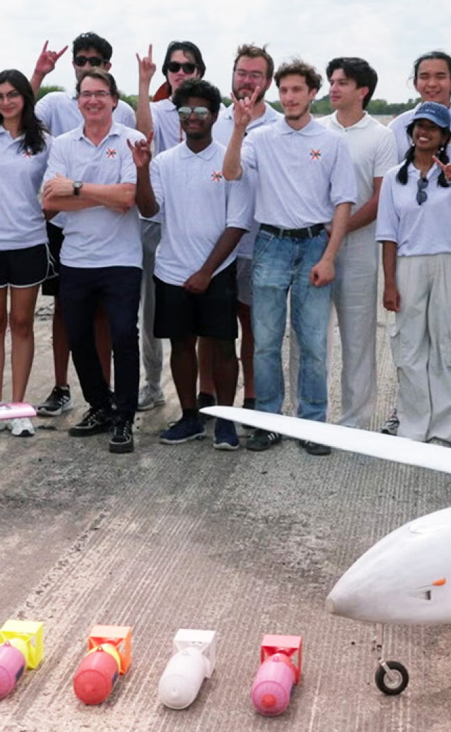 UT Austin's team for the XPRIZE Wildfire Competition stands behind the planes they built