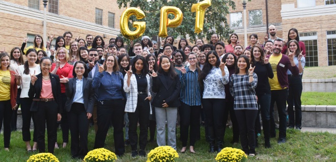 participants in GPT asia 2019 hold up a hook em and pose on campus 