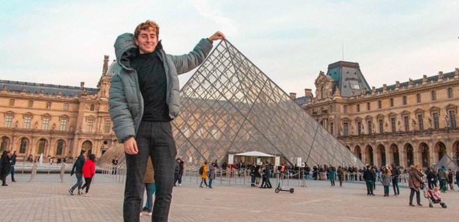 Male college student in front of the Louvre in Paris.