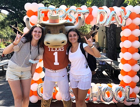 Two female students pose with Bevo mascot on first day of school