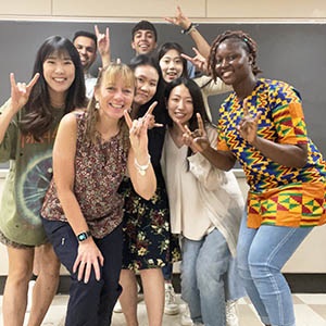 Dr. Melissa Ferro throws the Hook 'em horns with ELC students in classroom