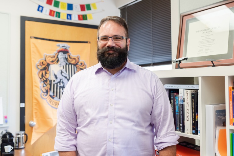 Dr. Connolly in front of a Hogwarts Hufflepuff banner in his office