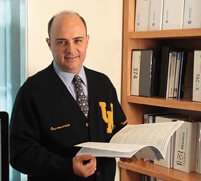 Sergio Alcocer, UT alumnus and director of UNAM's Engineering Institute, holds a book