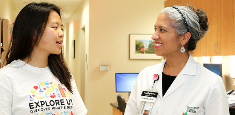 A female UT student converses with a University Health Services doctor