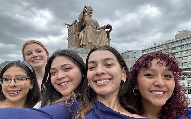 Global Ambassador students in Seoul gather in front of a statue