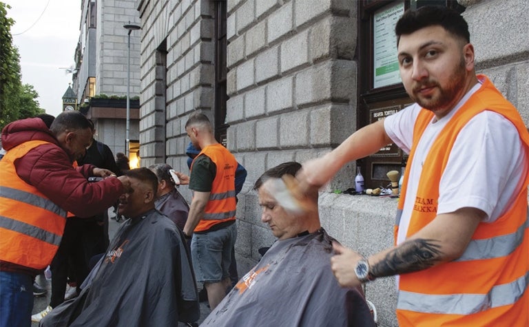Street barbers deliver haircuts on the streets of Dublin. 