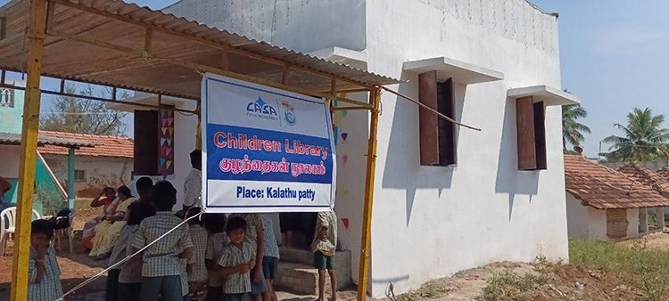 A sign hangs next to a school being built by UT students in Kalathupatty, India