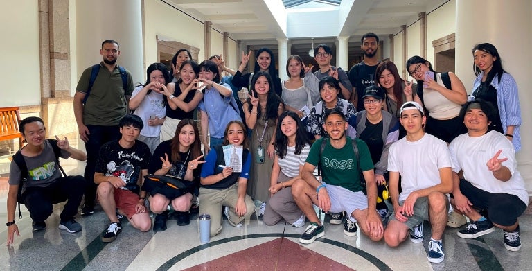 Group photo of UT students in a hallway