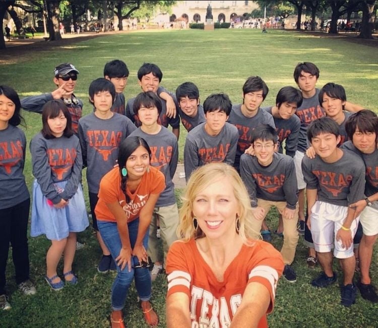 Students pose for a picture in front of the UT Austin South Mall.