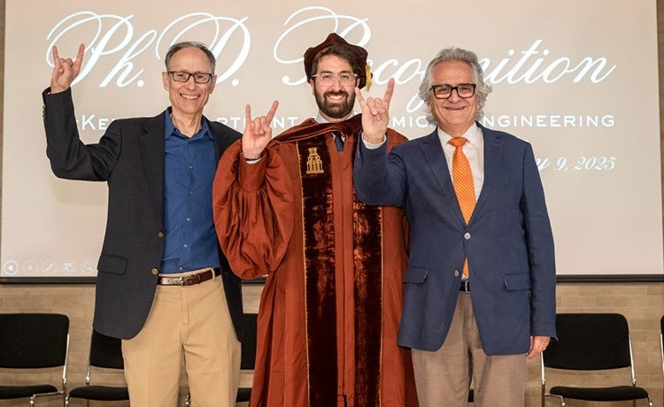 Keith Johnston, Antoine Chamoun-Farah, and Habib Chamoun throw the Hook 'em Horns sign