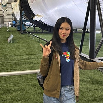 UT English Language Center student Yang Shao shows Hook 'em Horns