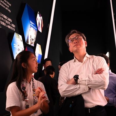 UT alum Anna Esaka converses with a patron at the Osaka World Expo in Japan