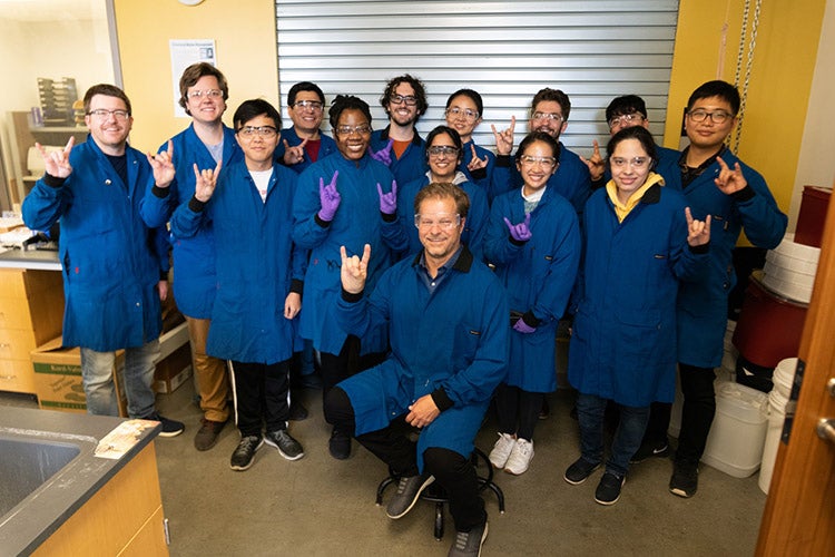 Dr. Brian Korgel and his research group in blue coveralls