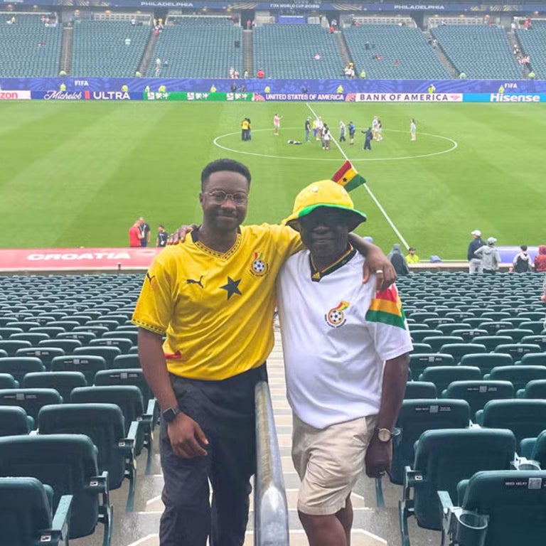 A man and his father at the world cup in Ghana jerseys.