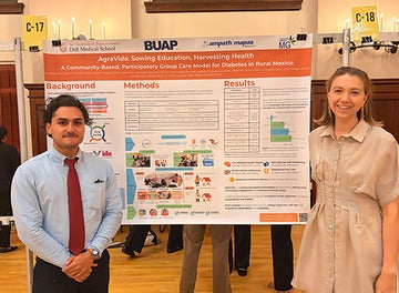 Medical students present a poster at a health conference.