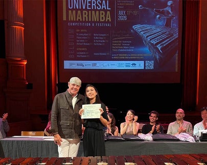 A woman recieves an award in a music performance hall.