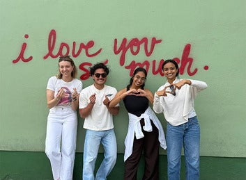 Students pose in front of Austin's "I love you so much" mural
