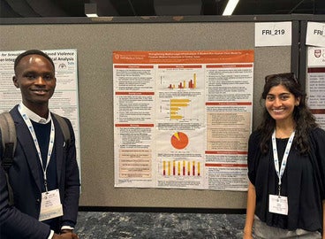 Medical students present a poster at a health conference.