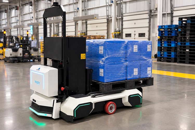 A driverless forklift built by Doozy Robotics carries a load in a warehouse